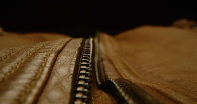 Close up of zipping up a leather jacket, macro shot of zipper on brown leather bag, everyday task, dramatic look, red epic