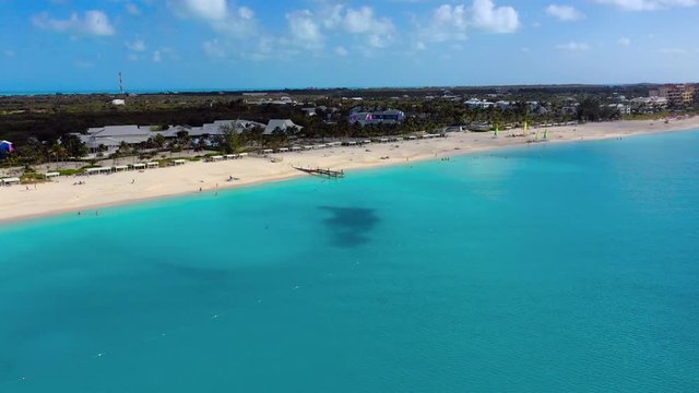 Aerial: Gorgeous Aquamarine Water, Beach and Water Sports With Beachfront Hotels and Palm Trees - Providenciales, Turks and Caicos