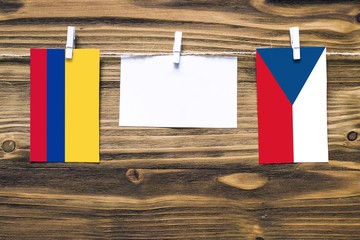 Hanging flags of Colombia and Czech Republic attached to rope with clothes pins with copy space on...