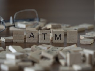 Naklejka na ściany i meble The concept of Atm represented by wooden letter tiles