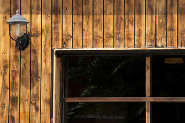 Fachada de madera con lampara marina y ventana
