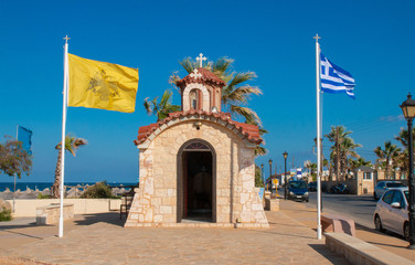Church of Agios Dimitrios, Analipsi, Crete, Greece.  Analipsi beach with palms and Church Saint Dimitrios.