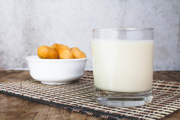 Soy milk in a glass and cup of fried cassava flour Resting on a brown wooden table