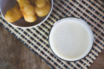 Soy milk in a glass and cup of fried cassava flour Resting on a brown wooden table. top view