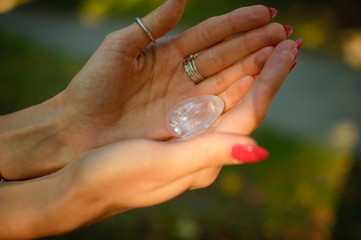 Female hand with transparent amethyst quartz yoni egg for vumfit, imbuilding or meditation. Shining...
