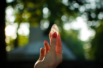 Female hand with transparent amethyst quartz yoni egg for vumfit, imbuilding or meditation. Shining...