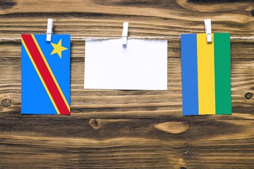 Hanging flags of Congo and Gabon attached to rope with clothes pins with copy space on white note...