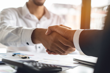 Banker and client shaking hands after business loan grant.
