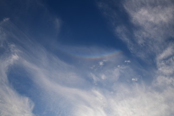 ほんの微かに、環天頂アーク、逆さ虹。青空。太陽は右下。背景素材。