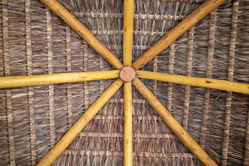 Inside a beach hut made of symmetrically straw and wood