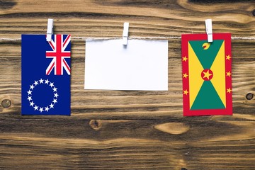 Hanging flags of Cook Islands and Grenada attached to rope with clothes pins with copy space on...