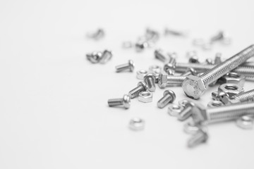Selective focus of Many nuts and bolts  on white background