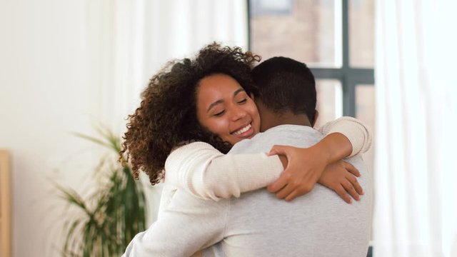 love, relationships and people concept - happy african american couple hugging at home
