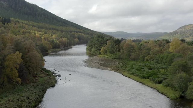 Aerial view of the River Dee near the Scottish town of Ballater in the Cairngorms National Park, Aberdeenshire. Low elevating view from above the river with zoom in.