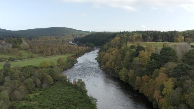 Aerial view of the River Dee near the Scottish town of Ballater in the Cairngorms National Park, Aberdeenshire. Flying forward over fields and the river.