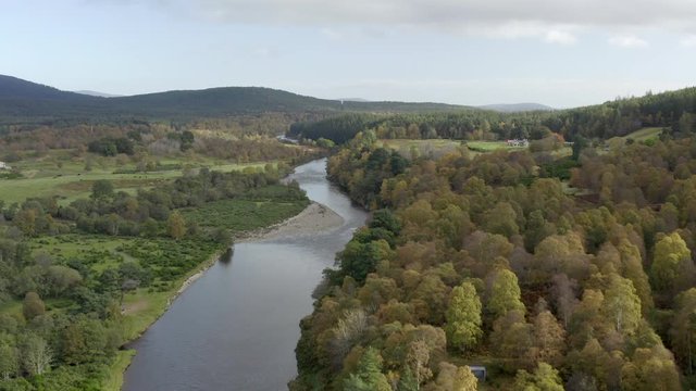 Aerial view of the River Dee near the Scottish town of Ballater in the Cairngorms National Park, Aberdeenshire. Elevating view above the river and autumn trees.