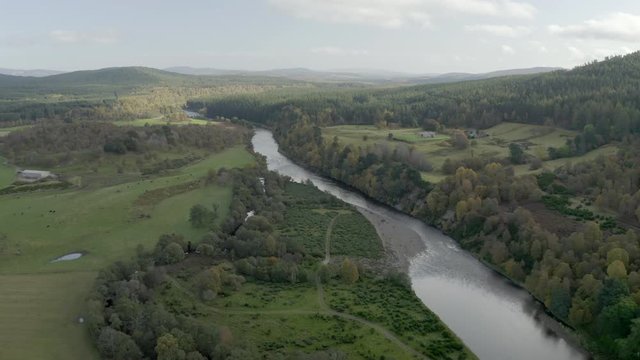 Aerial view of the River Dee near the Scottish town of Ballater in the Cairngorms National Park, Aberdeenshire. Flying forward over fields and the river.