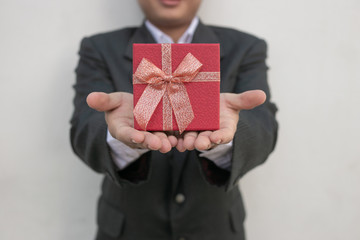 Businessman holds out the gift box ,isolated background Promotions and bonuses. Getting clients interested. Best offers.