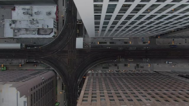 Aerial: Drone panning over elevated railway tracks over street amidst buildings in city - Chicago, Illinois
