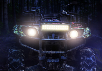Dirty atv vehicle standing in forest close-up view. © breakermaximus