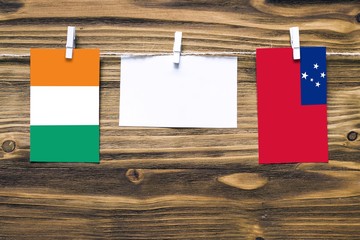 Hanging flags of Cote D'Ivoire and Samoa attached to rope with clothes pins with copy space on...