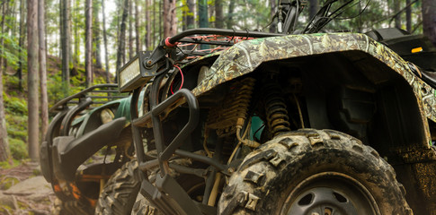 Atv vehicles standing in forest close-up profile view. © breakermaximus