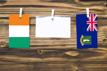 Hanging flags of Cote D'Ivoire and British Virgin Islands attached to rope with clothes pins with...