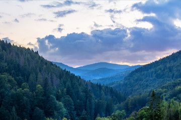 Landscape photo of wood mountains with blue early morning sky.