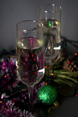 Glasses with white wine and Christmas decorations on a gray background. Christmas and new year celebrations