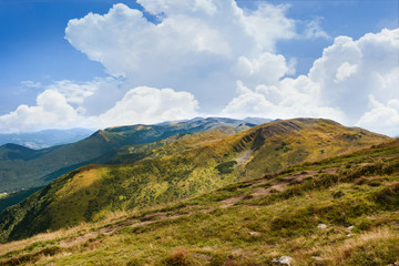 Landscape photo of mountain hills with blue sunny day sky.