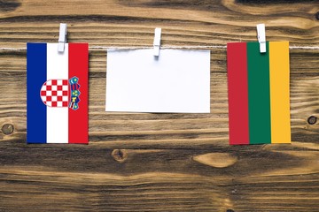 Hanging flags of Croatia and Lithuania attached to rope with clothes pins with copy space on white...