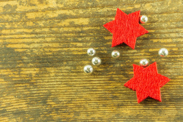 red stars and bright beads lie on an old wooden board - 299677906