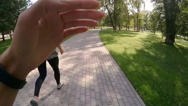 POV Shot Of Woman Running After Athletic Man In Sportswear While Exercising Together In Park On Summer Day