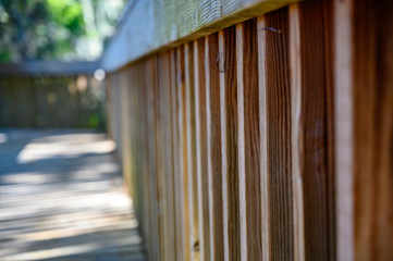 View along a natural pine wood slat fence