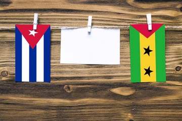 Hanging flags of Cuba and Sao Tome And Principe attached to rope with clothes pins with copy space...