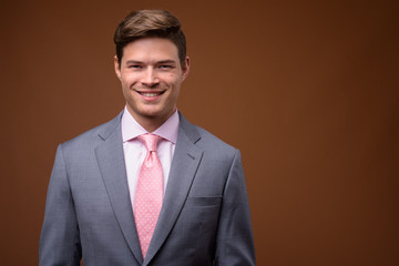 Studio shot of young handsome businessman in suit