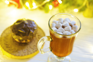 Hot drink with marshmallows on the background of Christmas decorations