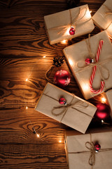 Christmas composition. Gifts, red decorations, Christmas balls, Christmas candy and garland on a wooden background. Christmas, winter, new year concept. Flat lay, top view, copy space