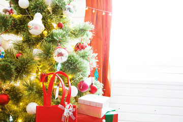 Fototapeta na wymiar Elegant christmas tree with decorations and gifts on elegant hardwood floor over window