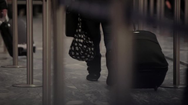 Close up scene of airline passengers pulling luggage at airport
