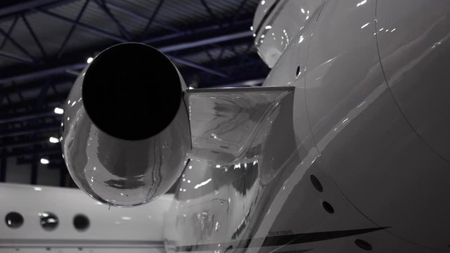 Close up scene of rear end of jet engine - on private business jet parked in hangar