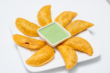 Colombian empanadas, chili and lemon on white wooden boards