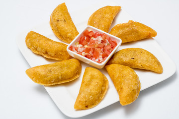 Colombian empanadas, chili and lemon on white wooden boards