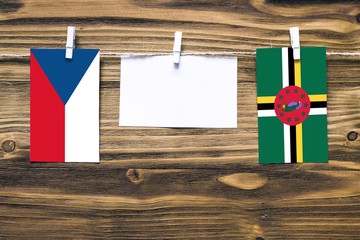 Hanging flags of Czech Republic and Dominica attached to rope with clothes pins with copy space on...
