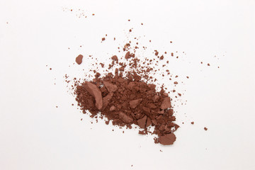 This is a photograph of a deep Brown Powder Eyeshadow isolated on a White Background