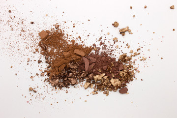 This is a photograph of a Matte Brown, Metallic Gold,and Deep Brown Powder Eyeshadow isolated on a White Background