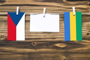 Hanging flags of Czech Republic and Gabon attached to rope with clothes pins with copy space on...