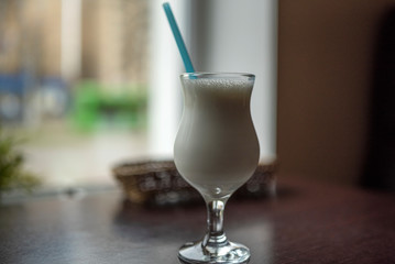 Milkshake on a table in a cafe. Photographed close-up.