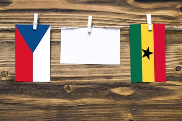 Hanging flags of Czech Republic and Ghana attached to rope with clothes pins with copy space on...
