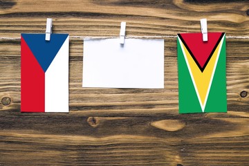 Hanging flags of Czech Republic and Guyana attached to rope with clothes pins with copy space on...